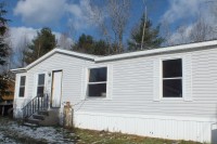 A photo of a white single-wide manufactured home.